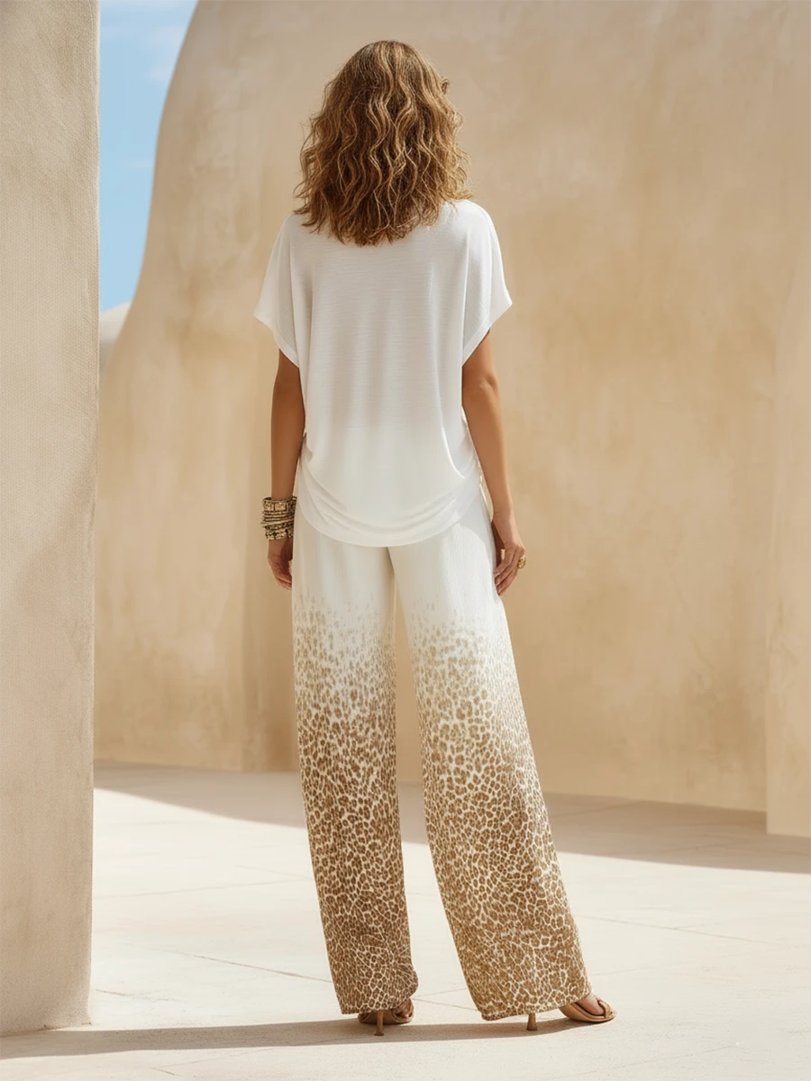 Conjunto compuesto por un top blanco con cuello en V y unos pantalones anchos con estampado de leopardo degradado