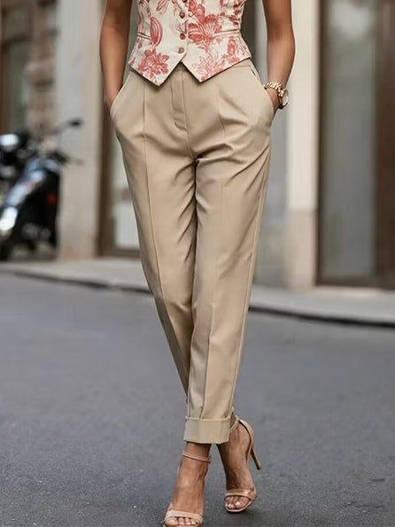 Conjunto de dos piezas compuesto por un chaleco con estampado floral en tonos caqui y rojo y unos pantalones ajustados